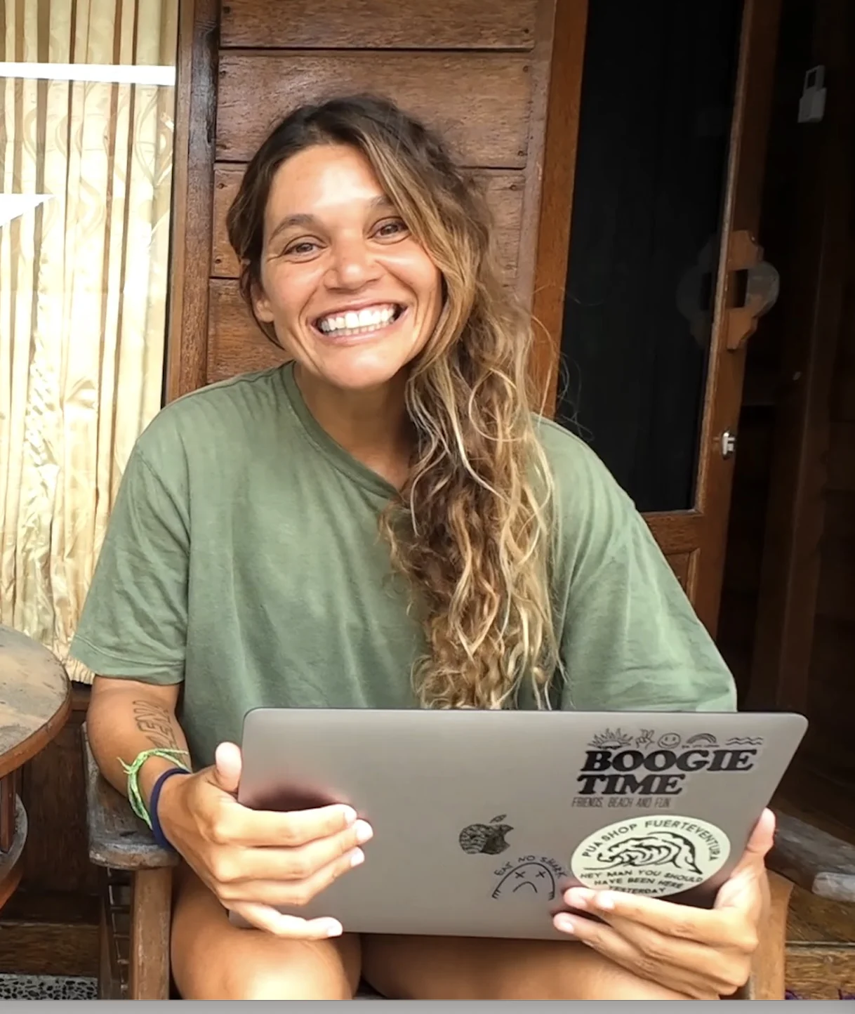 Isabela Sousa sentada com o computador e o módulo do treinamento
